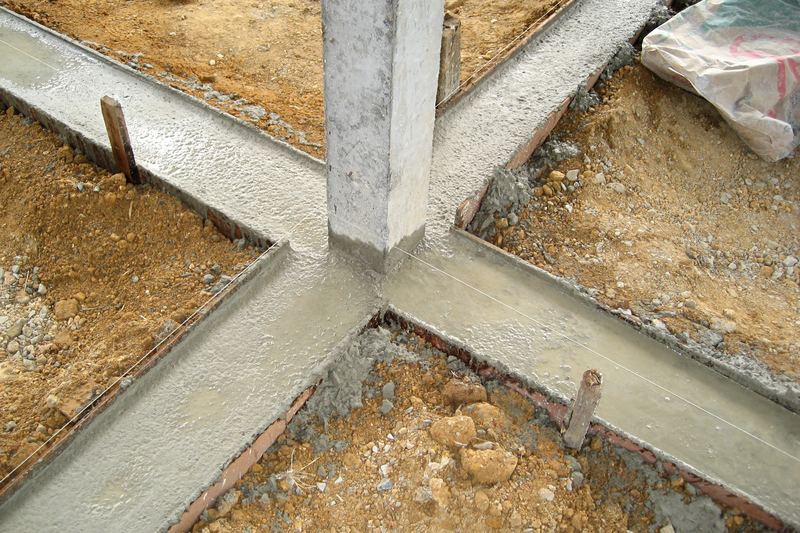 A Thai house building project in Trat Province, Thailand. The concrete footing around a pole has just been poured.